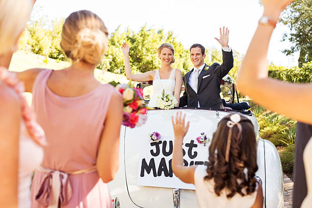 casal feliz no conversível carro a acenar aos clientes - traditional ceremony sign symbol wedding imagens e fotografias de stock