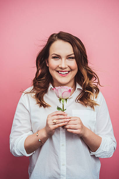 mujer joven con la flor color rosa - single flower flash fotografías e imágenes de stock