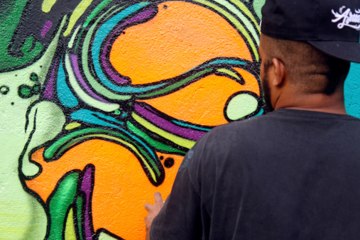 São Paulo, SP, Brazil - April 1, 2012: young man graffiting an external wall of Quilombaque Cultural Center during a graffiti festival.