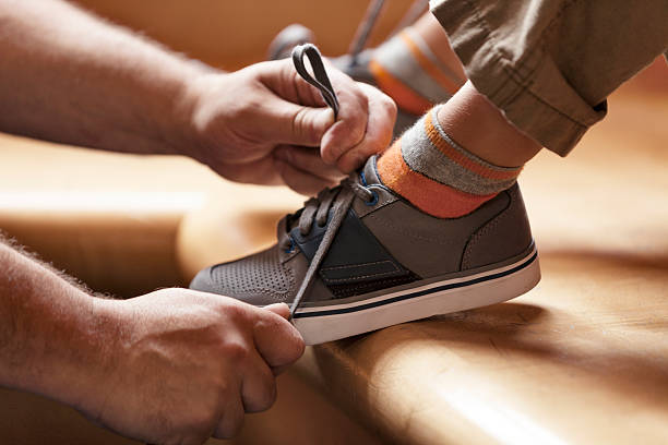 Dad Helping Tie Shoes Father helping to tie his son's shoes child tied up stock pictures, royalty-free photos & images