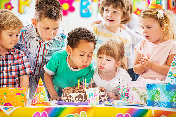 soplando velas de cumpleaños para niños. - birthday party fotografías e imágenes de stock