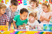 Children blowing birthday candles.