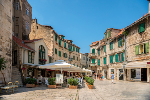 Split, Croatia - June 13, 2014: Tourists in visit of the old town of Split. Tourists walking, sitting in caffe bars and restaurants. Visible and recognisable faces, brands and logoes along the street