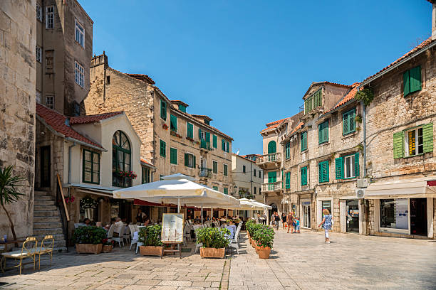 Inside the Old town Split Split, Croatia - June 13, 2014: Tourists in visit of the old town of Split. Tourists walking, sitting in caffe bars and restaurants. Visible and recognisable faces, brands and logoes along the street wall sidewalk city walking stock pictures, royalty-free photos & images