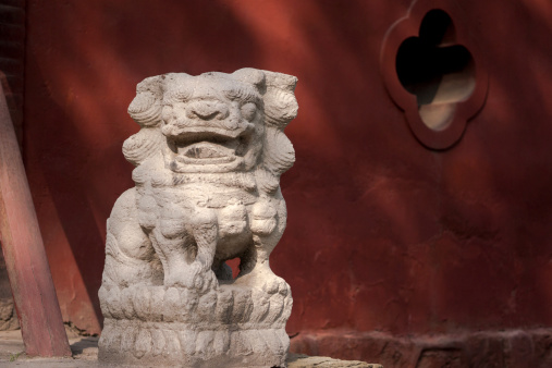 stone lion and red wall