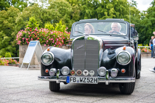 Bad Nauheim, Germany - August 17, 2014: Mercedes 220 S Roadster at a classic car meeting. This car was produced from 1951 to 1955. Two people can be seen inside the car. Today Mercedes Benz is German car manufacturer and part of the Daimler AG.. This car was seen at a classic car meeting at Bad Nauheim.