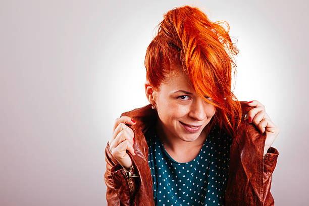 Portrait of a beautiful red-haired girl with straight hair. The girl looks to the side on a white isolated background with space to copy. High quality photo