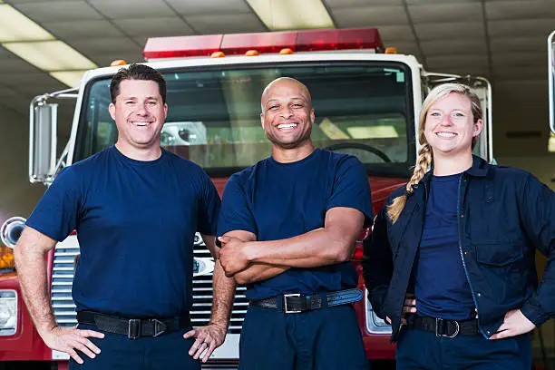 Photo of Diverse team of firefighters in front of fire engine