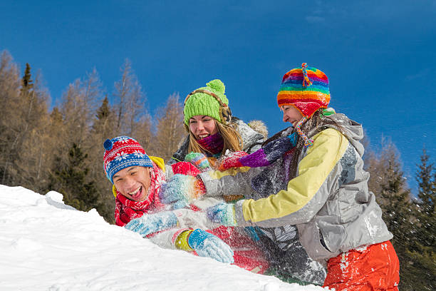 istock Three smiling young people in winter clothes lying on snow 508487142