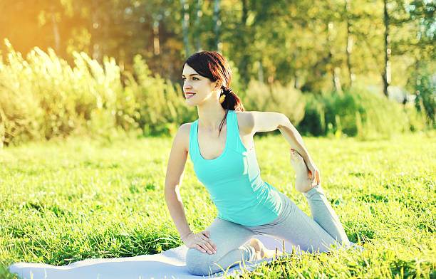 istock Young woman doing yoga exercises on grass in summer 508490746
