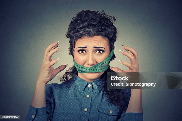 Diet Restriction Stress Frustrated Woman With Measuring Tape Around Mouth Stock Photo - Download Image Now