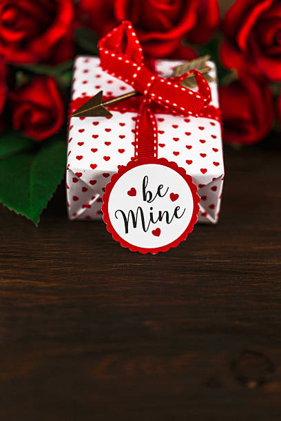 istock Valentine rose bouquet on wooden table with gift and message 508492396
