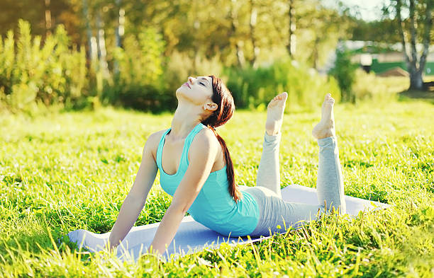 istock Woman doing yoga stretching exercises on grass 508493646