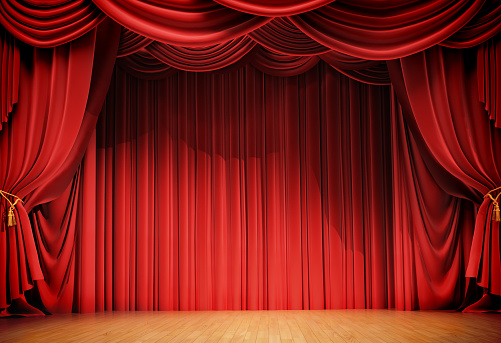 Empty theater seats facing a closed red velvet curtain on a dark stage, creating a sense of anticipation.