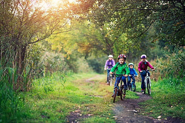 rodzina jazdy rowerami w pięknym natura - candid people casual bicycle zdjęcia i obrazy z banku zdjęć