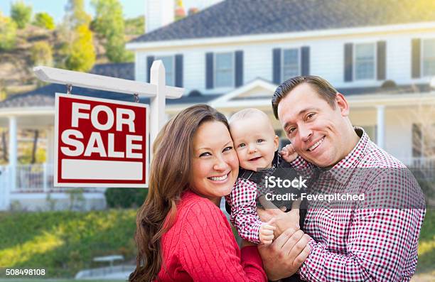 Young Family In Front Of For Sale Sign And House Stock Photo - Download Image Now - Home Ownership, Selling, Family