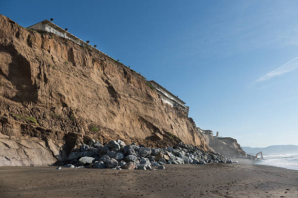 Pacifica California cliff erosion Pacifica California ocean cliff erosion issues and distant work being done to save them. ocean beach papua new guinea stock pictures, royalty-free photos & images