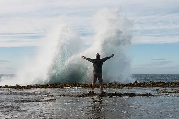 Photo of Man in front of splashing wave