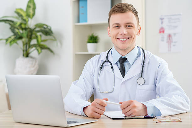 istock Smiling pediatrician sitting at the table 508508620