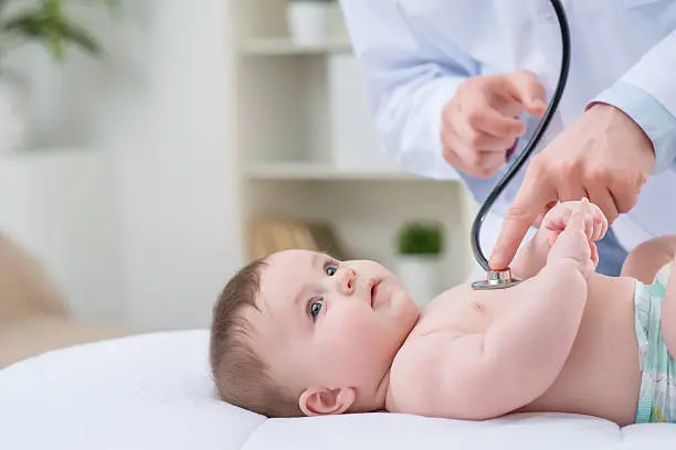 Photo of Professional pediatrician examining infant