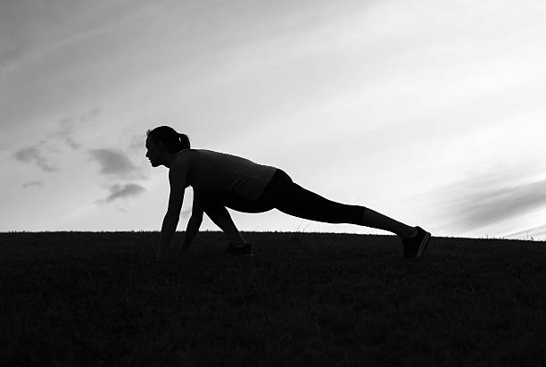 silhouette of a woman at sunset yoga cloudy sky