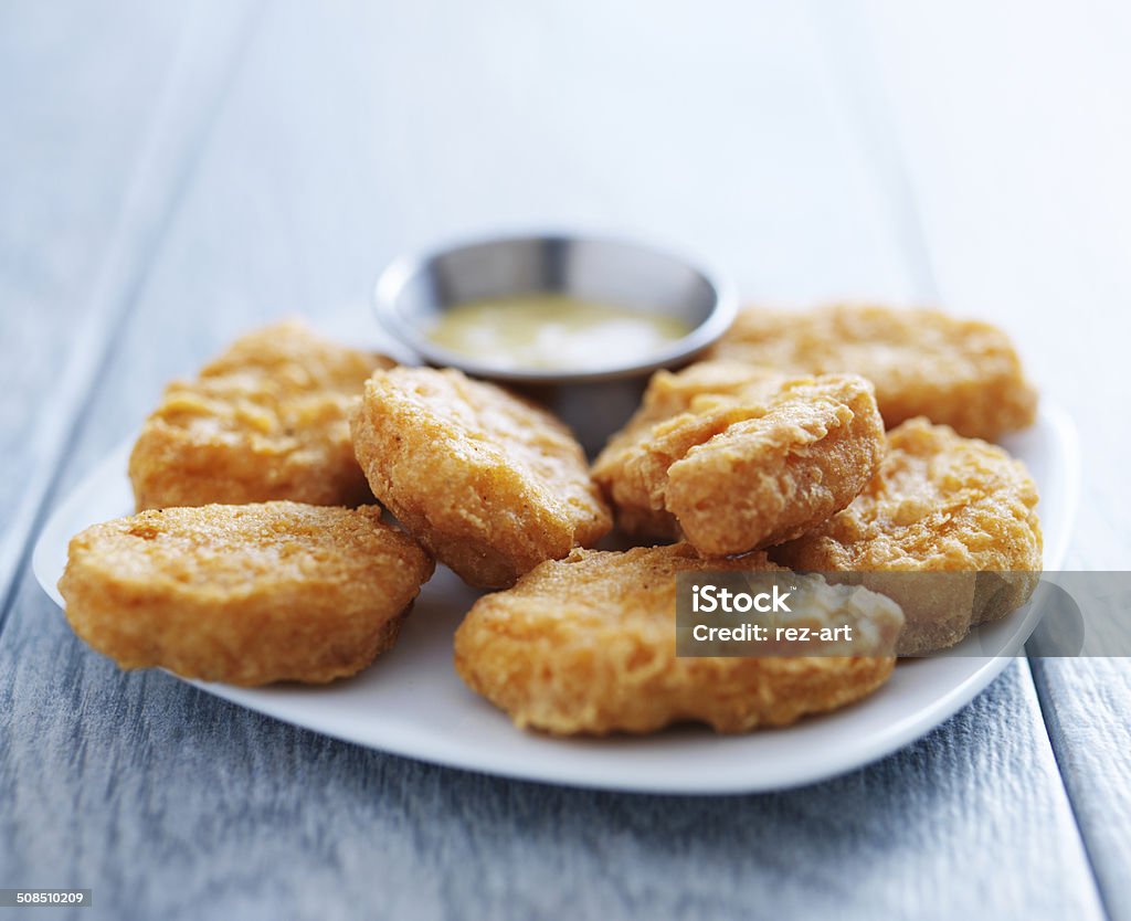 chicken nuggets with honey mustard in natural light chicken nuggets with honey mustard in natural light close up photo American Culture Stock Photo