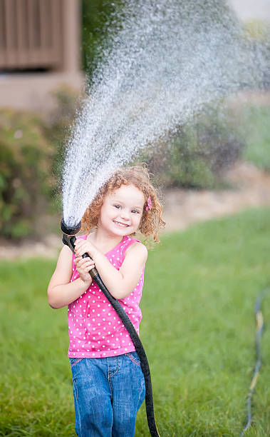 istock Girl Playing With Garden Hose 508510339