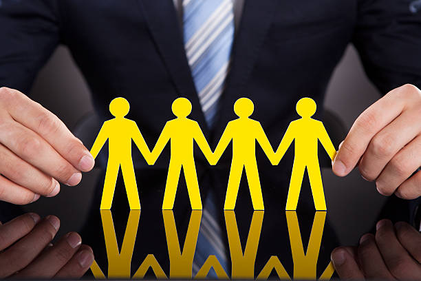 istock Businessman's Hands Holding Paper People Chain On Desk 508511079