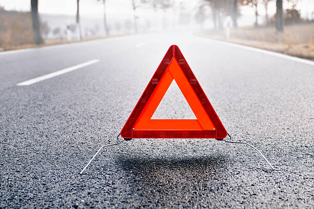 istock Bad Weather Driving - Warning Triangle on a Misty Road 508512015