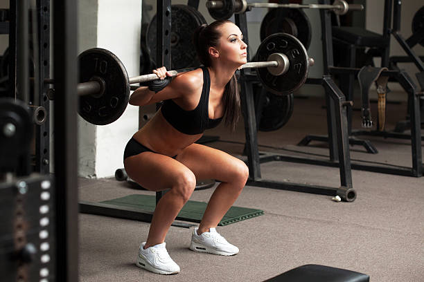 istock Beautiful girl exercising squatting with barbell 508512057