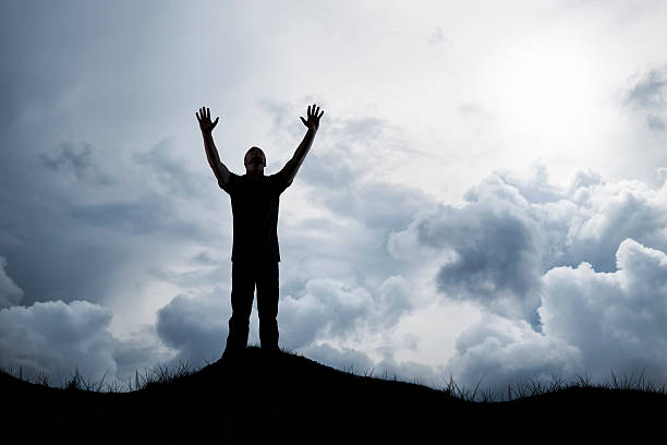 istock Man Reaches Out to God as Storm Clouds Gather 508514131