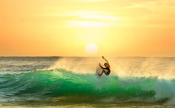 Surfer at sunrise on a wave