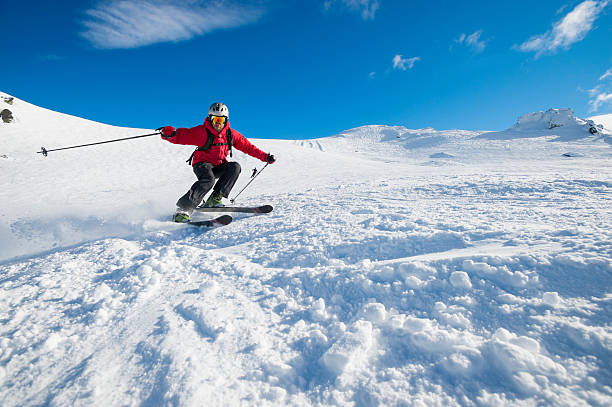 skieurs tourner sur un ciel bleu jour - action snow adult skiing photos et images de collection