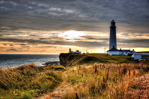 istock White lighthouse against dark sky at sunset 508516077