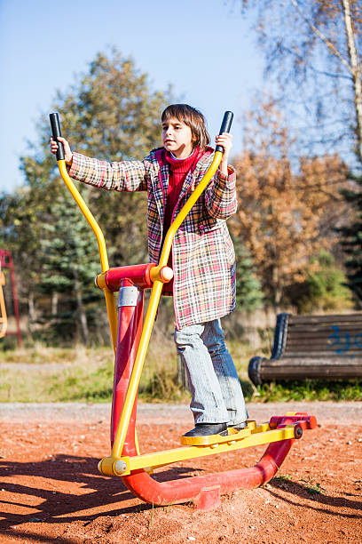 istock Little girl does exercises on the simulator in park 508516079