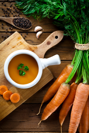 Preparing Carrot Soup on Wood Background.