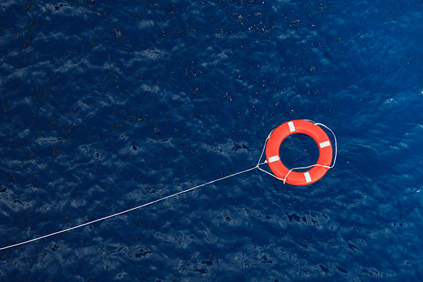 lifebuoy num turbulentas do mar azul, equipamento de segurança em barco - save oceans imagens e fotografias de stock
