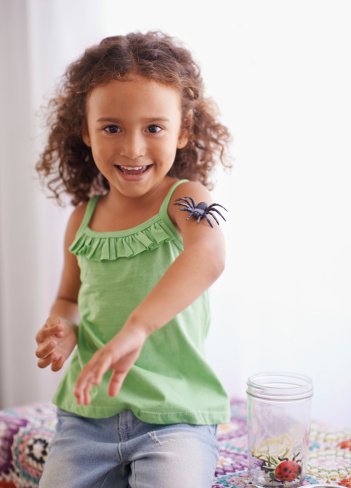 Portrait of a young girl playing happily in her bedroom