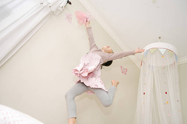 istock Little girl dancing on her bed with a butterfly 508517080