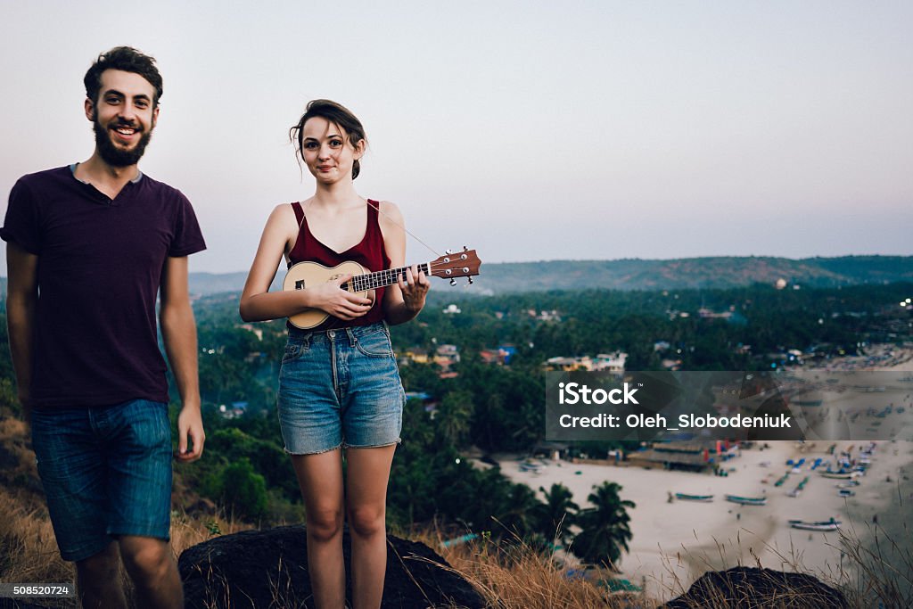 Woman and man near the beach Woman with ukulele and man standing on the background of the beach  Adult Stock Photo