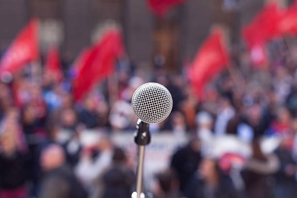 Public demonstration. Protest. Microphone in focus against unrecognizable crowd left wing politics stock pictures, royalty-free photos & images