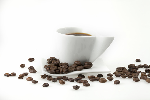 Cup of coffee and coffee beans isolated on white