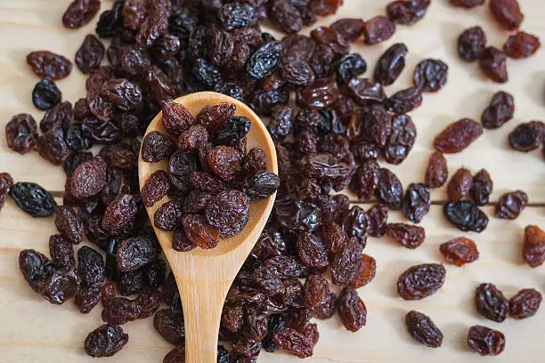 Raisins in a wooden spoon, close-up