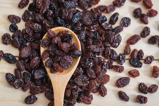 raisins em uma colher de pau - shiny group of objects high angle view close up imagens e fotografias de stock