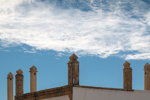 Corner of a roof with many traditional chimneys. Cloudy sky. Essaouira, Morocco.