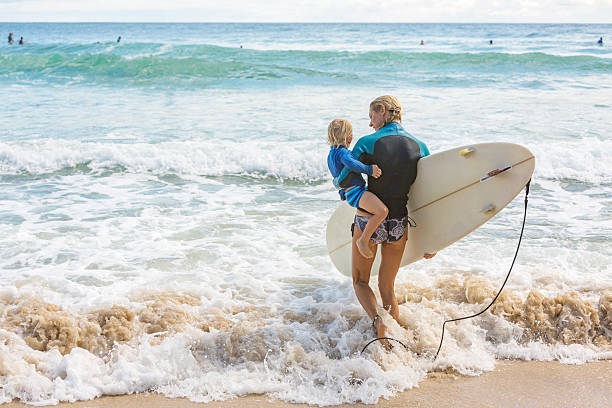 istock Mother Taking Her Young Child Surfing at the Beach 508541372