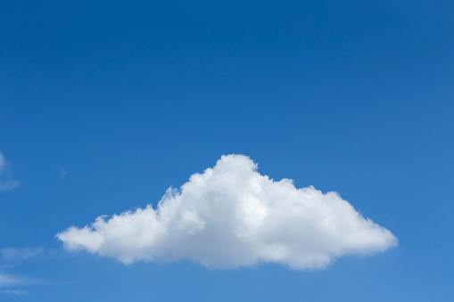 fluffy single cloud on clear blue sky background