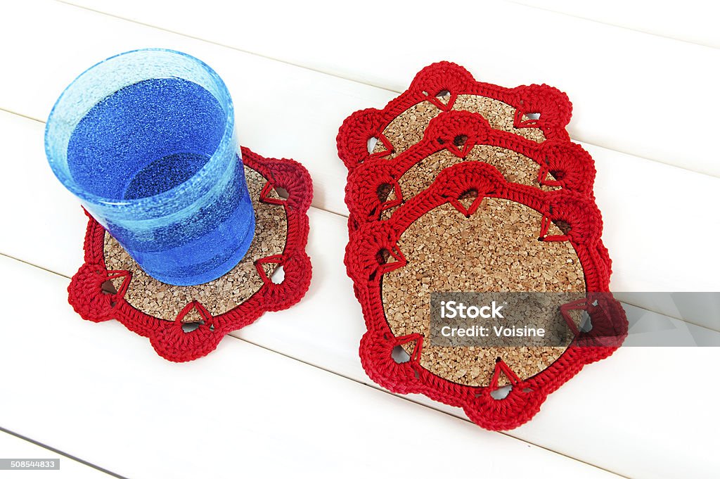 Crochet coaster Blue glass on crochet red coaster with cork base Art And Craft Stock Photo