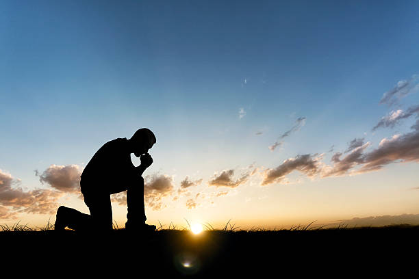 istock Praying Outside on Field at Sunset 508544907