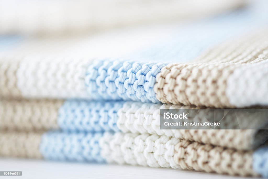 Knitted baby blanket Handmade knitted baby blanket in soft colours on baby cot Art And Craft Stock Photo